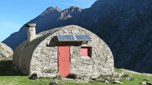 Refuge Ledormeur au fond du Val d’Azun, en pierre, sous une falaise