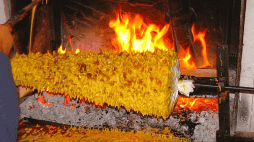 Cuisson du gâteau à la broche sur feu de bois