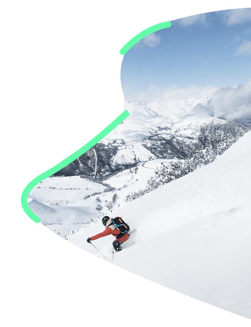 skieur en train de dévaler en hors piste dans la neige avec les montagnes en fond