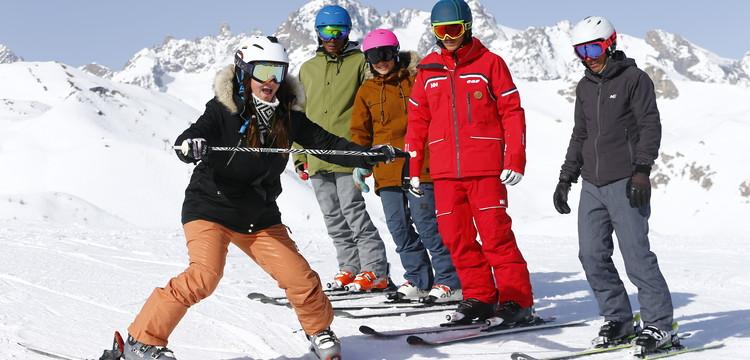 groupe de personnes apprenant à skier sur piste de ski enneigé montagnes en fond